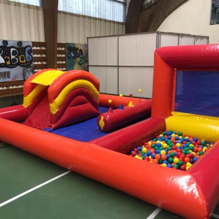 Structure gonflable, play zone rouge dans une salle de sport avec piscine à boules, et petit toboggan , Jump'O'Clown