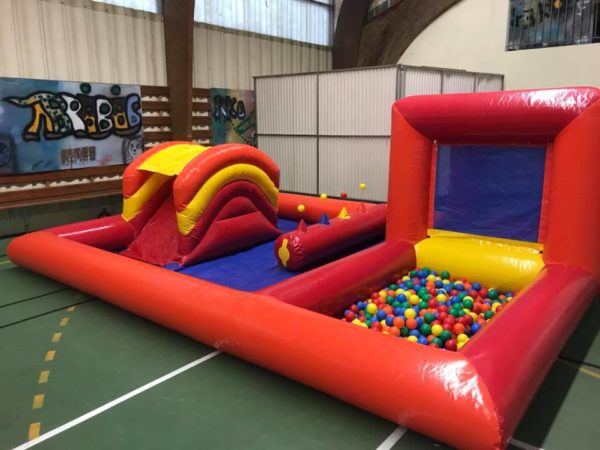Structure gonflable, play zone rouge dans une salle de sport avec piscine à boules, et petit toboggan , Jump'O'Clown