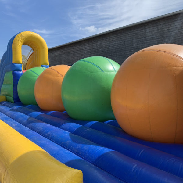 Zoom sur la structure gonflable, wipe out, parcours gonflable coloré vert orange bleu et jaune, Jump'O'Clown