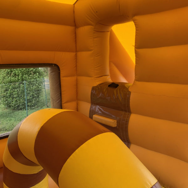 Intérieur de la structure gonflable, château gonflable, maison toboggan western, obstacle arche jaune et marron, dans un jardin, avec le Jump'O'Clown